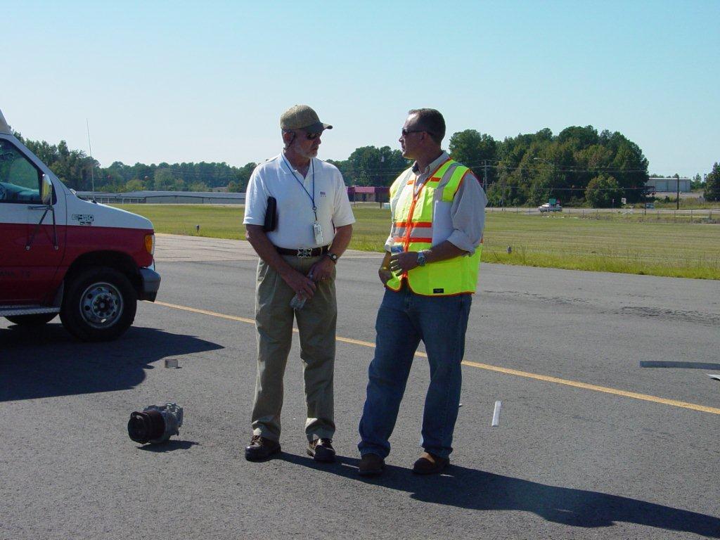 Two officers standing on the airport runway.